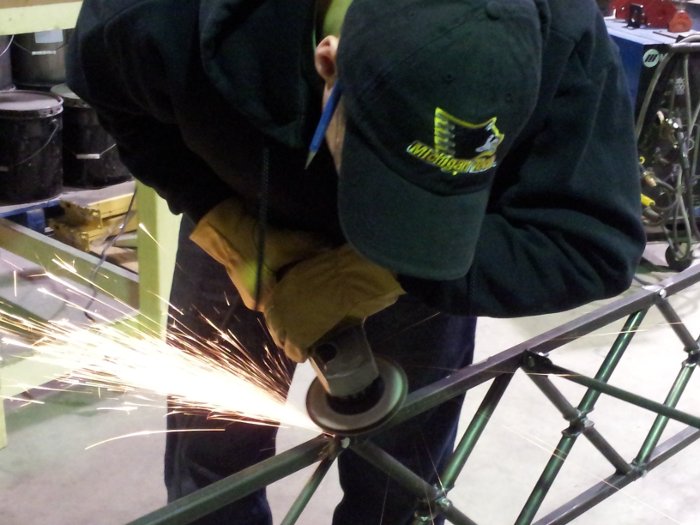 Bridge builder Steel Bridge team member Woody Beardsley grinds the top rails of Michigan Tech's Steel Bridge entry to make them smooth.