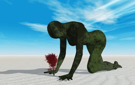 Graphic of a large green person crawling in the sand over a tree.