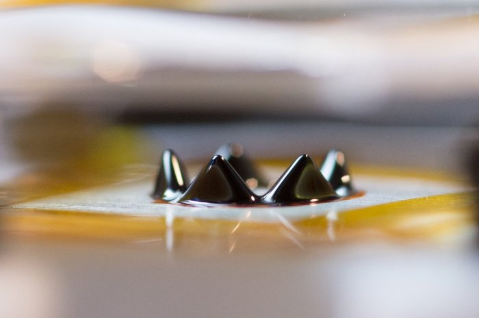 A liquid crown L. Brad King's prototype of a ferrofluid ion thruster. When subjected to voltage, the points of the crown arise from a ring-shaped trench circling a one-inch block of aluminum. Sarah Bird image
