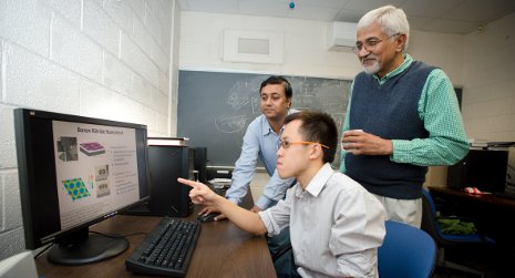 Sanjeev Gupta and Jarvis Loh work with Physics Chair Ravindra Pandey on his graphene research.