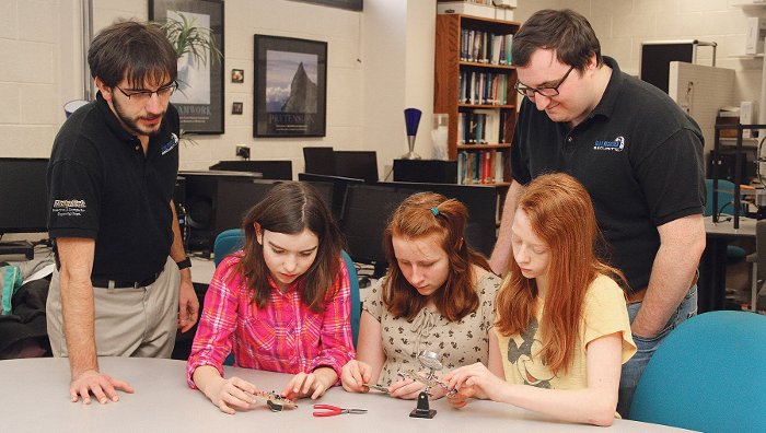 Blue Marble Security Enterprise students help middle schoolers assemble a heart monitor from a kit designed and built by the Enterprise. From the left, Philip Wolschendorf, Olivia Hohnholt, Hannah Hansen, Geneva Archer and Mike Switala.