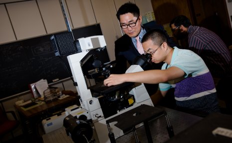 C.K. Choi, left, and PhD candidate Shuo Wang    examine flow fields in a micro-channel, using the Nikon TI series inverted microscope. 