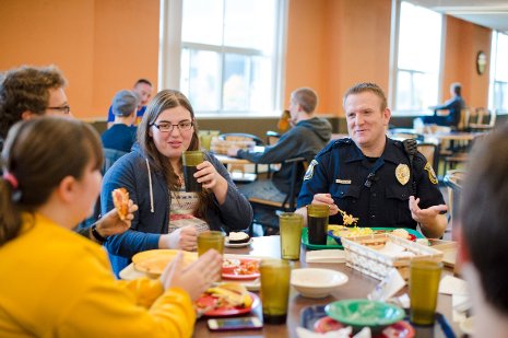 Officer Reid DeVoge sits down for dinner with residents in Wadsworth Hall as part of the Residential Officer Program.
