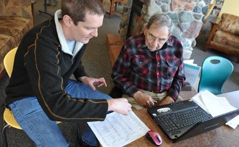 Chuck Wallace, at left, helps Bob Veeser use his computer.