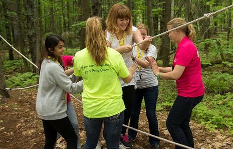 This exercise tests balance and teamwork. . The metal cable is taut, but the cotton ropes are very loose and cross in the middle. The trick is to keep your body straight, lean into the ropes and trust your spotters. 