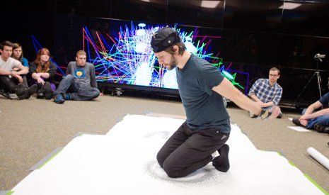 Visiting Artist Tony Orrico Orrico kneels on a large piece of paper, creating a piece of art while his movements are tracked by Tech's Mind Music Machine Lab researchers.