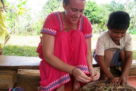 Peace Corps Masters International graduate student Erica Jones helps a village boy shuck beans in Panama.