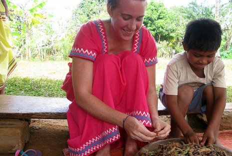 PCMI Peace Corps Masters International graduate student Erica Jones helps a village boy shuck beans in Panama.