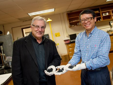 Rubber in the road David Hand, left, and Zhanping You hold samples of crumb rubber and chunks of rubber made from recycled tires. They are leading studies to help determine if asphalt made with crumb rubber could be used on Michigan roads. Sara Bird photo