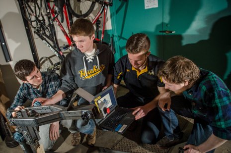 One of the Velovations Enterprise teams shows off the prototype for a wheelchair-friendly exercise machine. 