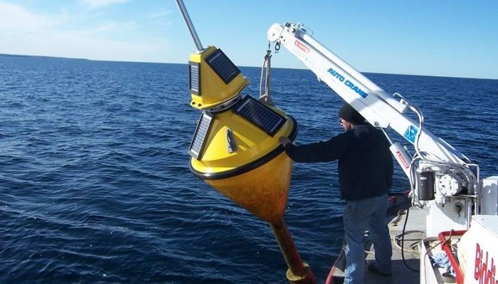 Deploying the buoy to monitor water conditions in the Straits of Mackinac.