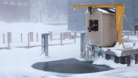 GLRC and Alliance for Coastal Technologies scientists lower test instruments and a video camera under the ice in the Portage Waterway.