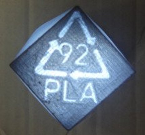 Recycling_PencilHolder Light shines through the bottom of a 3-D printed pencil holder, revealing its polymer resin code for recycling.