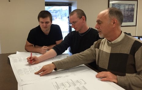 From the left,  Troy Johnston and Bob Elsey, interns at Systems Control's Houghton office, work with Tech alumnus John Zipp, senior protection and control engineer, on a schematic for a bus differential panel to be incorporated into an electrical transmission substation control house.