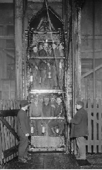 Twelve plus miners in a wooden cart on a pully system
