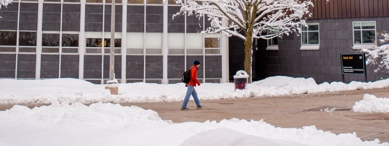 Student walking between Rekhi and Fisher Hall in winter.