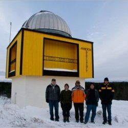 Students stand outside of observatory in winter