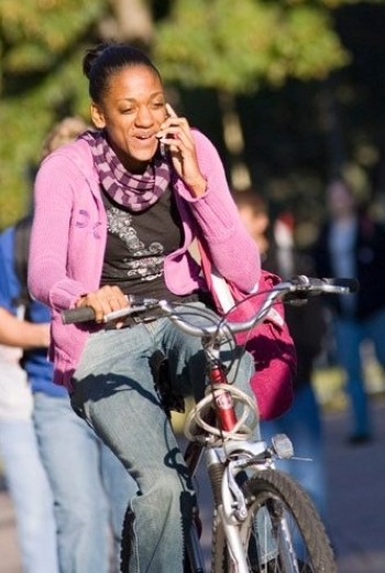 Woman biking across campus