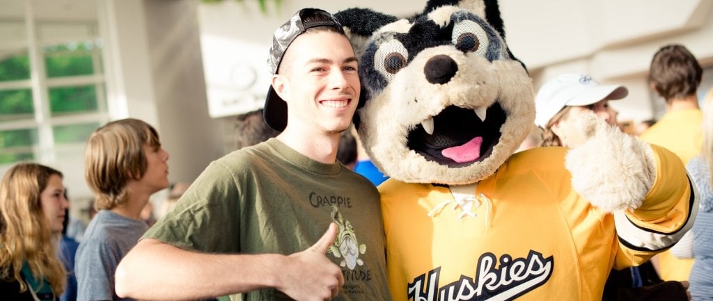 Student with Blizzard T. Husky with thumbs up