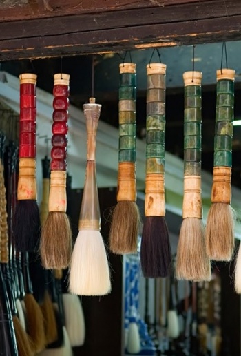 Colorful array of hanging paint brushes.