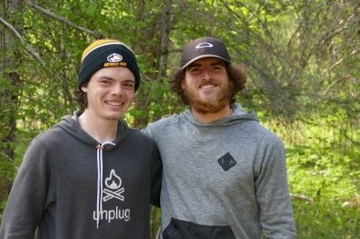 Two Michigan Tech students on a research expedition smile in the forest at Isle Royale.