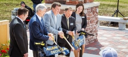 University leaders and lead donor Mike Trewhella â€™78 cut the ribbon on the Alumni Gateway Arch. From left: Bill Roberts, vice president for advancement and alumni engagement; President Rick Koubek; Trewhella; Steve Tomaszewski, Michigan Tech Board of Trustees chair; and Emily McDonald, Alumni Board of Directors president.