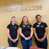 Three students in front of the Student Success sign.