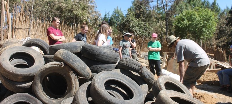 Students next to a pile of tires.