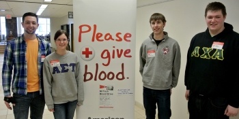 Blood drive students stand by floor poster