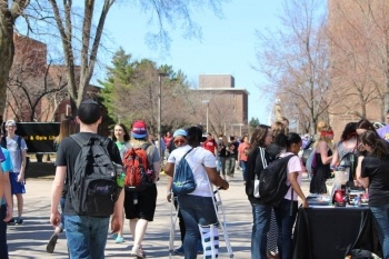 Students at a table and walking through campus.