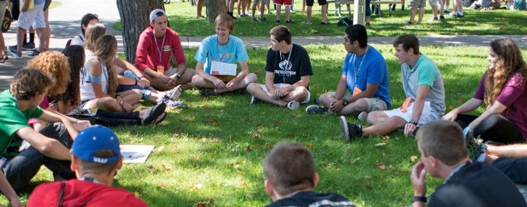 Students sitting in a circle on campus 