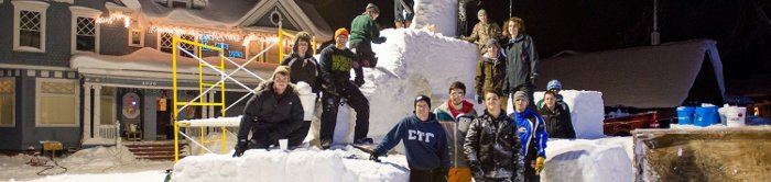 students posing with snow statue