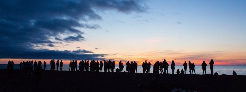 Silhouettes of SYP students watching a sunset on the beach. 