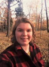 young woman in flannel shirt in the woods