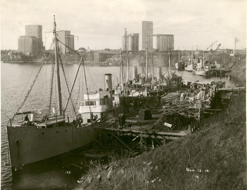 Newly built and outfitted minesweepers at the dock in a black and white photo from 1918 in a harbor on lake superior