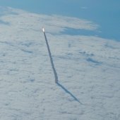 The space shuttle flying through a deck of clouds.