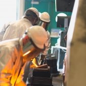 people in safety gear work with molten metal
