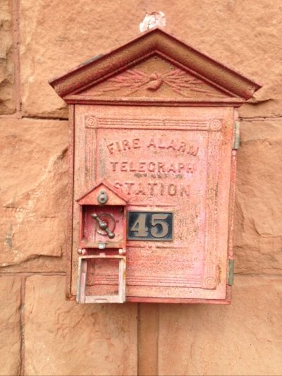 antique fire alarm with faded red housing