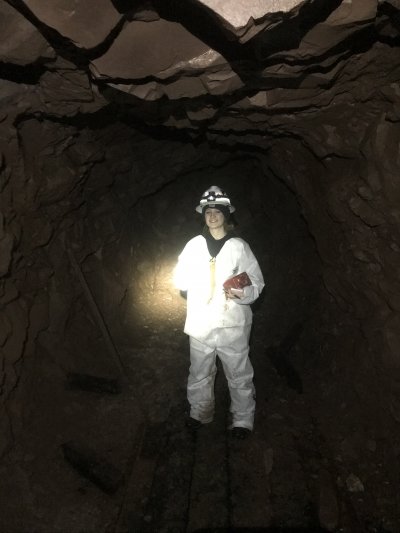 woman in hazmat suit in a dark tunnel