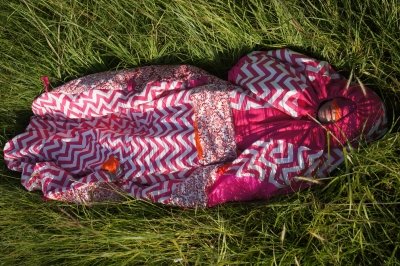 a person in a field, wearing a colorful onesie