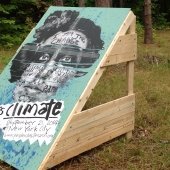 A teal People’s Climate March poster, attached to a wooden display stand, along the Tech Trails.