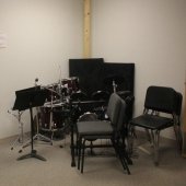 Chairs and music stands against a corner inside the Hagan Practice Room.