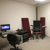 Another view of the Hagan Practice room with computer and desk with music stands and equipment.