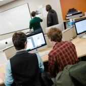 Students working at a computer and by the wall in the HDMZ.
