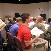Side view of a seated choir in the Choral Rehearsal Room.