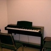 Inside one of the practice rooms that has a piano.
