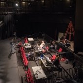 A view of the orchestra pit and the technical crew working with computers and sound equiptment.
