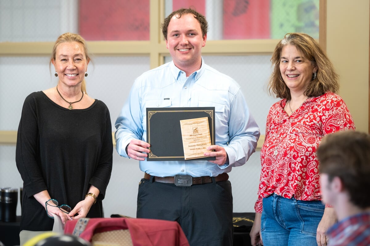A student holding their award with two faculty members. From left to right - Kerri Sleeman, Jeremy Haughian, Jen Miller
