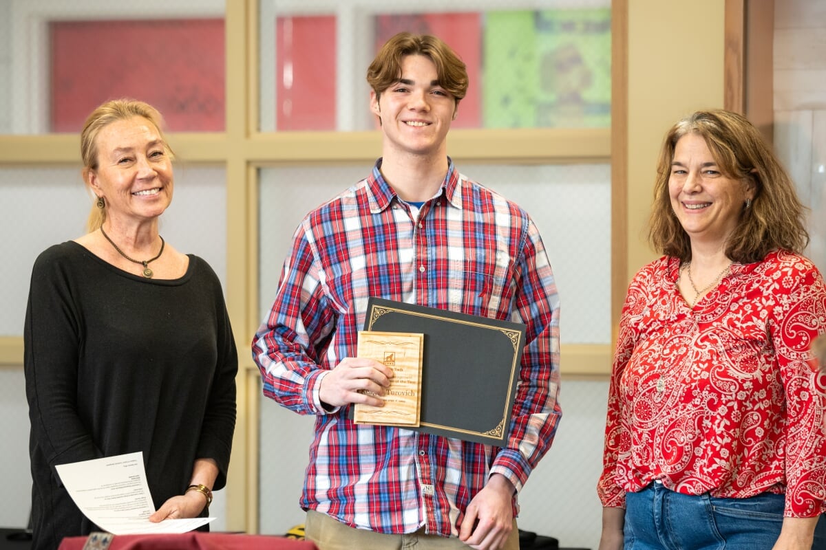 A student holding their award with two faculty members. From left to right - Kerri Sleeman, Keagan Turovich, Jen Miller