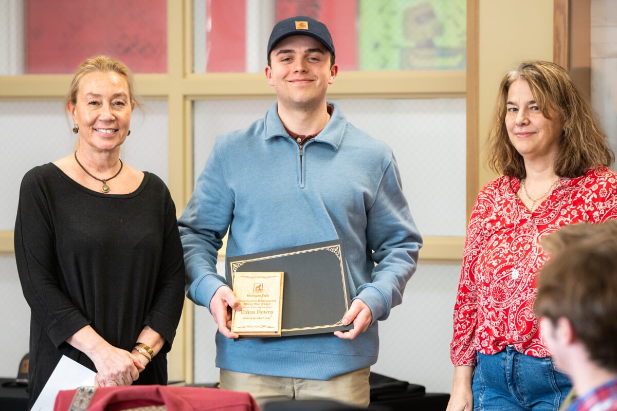 A student holding their award with two faculty members. From left to right - Kerri Sleeman, Ethan Downs, Jen Miller